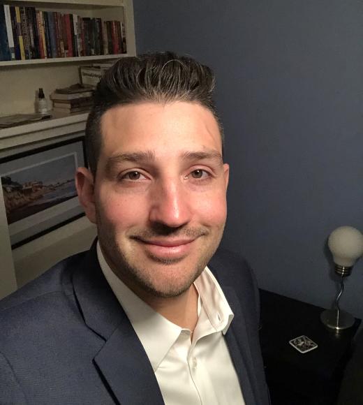 Man posing in front of bookshelf